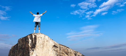 Man with arms raised in the sky