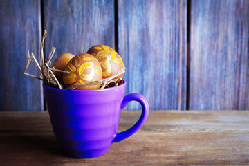 Easter eggs in mug on wooden background. Retro stylization