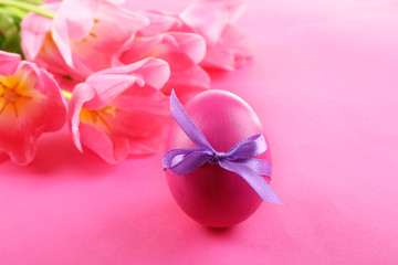 Easter egg and tulips on pink background