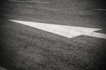 white directional arrow on blacktop