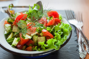 salad from fresh vegetables in a plate on a table, selective focus