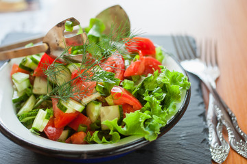 salad from fresh vegetables in a plate on a table, selective focus