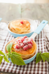 fritters in a frying pan and raspberry, selective focus