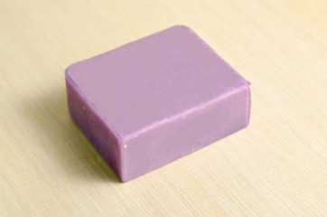 Soap bar flavor with lavender scent isolated on wooden board bac