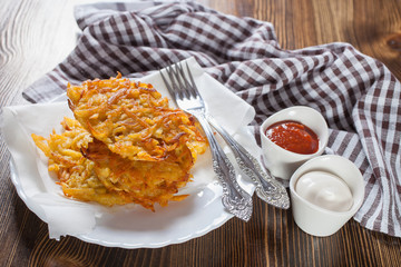 grated potatoes cutlets in a plate on a table, selective focus