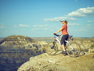 Fototapeta na wymiar Girl a bike in mountains.