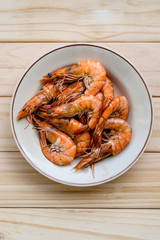 Grilled shrimps with herbs on wooden board