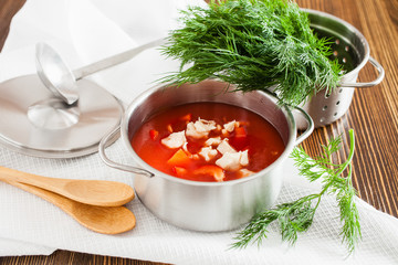 tomato soup and greens in a pan on a table, selective focus
