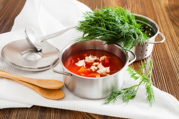 tomato soup and greens in a pan on a table, selective focus