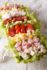 Tasty American Cobb salad close-up on a plate. vertical
