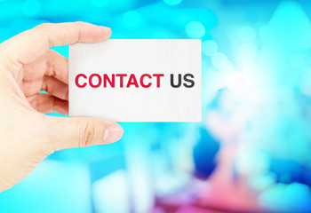 Hand holding Business card with contact us with blur blue bokeh