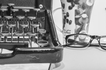 antique typewriter with coffe, a blank and a pencil on white background