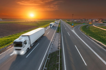 Delivery transport truck in motion blur on the highway at sunset