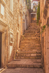 Fototapety  Wąska uliczka i schody na Starym Mieście w Dubrowniku, Chorwacja, śródziemnomorski klimat, ciepły filtr, flara obiektywu