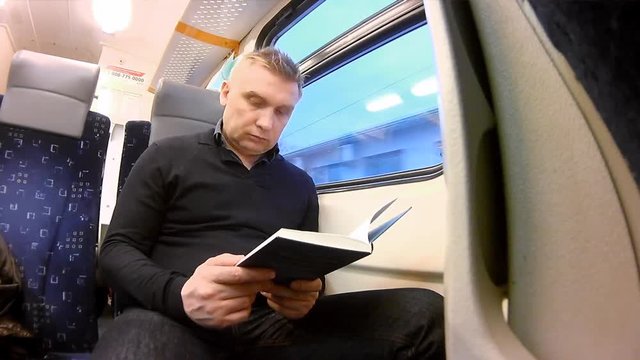 Man read book in a passenger train
