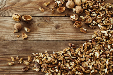 Obraz na płótnie Canvas Walnut kernels and whole walnuts on rustic old wooden table