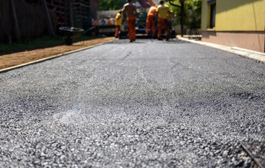 Team of Workers making and constructing asphalt road constructio