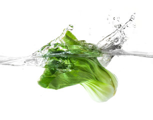 fresh vegetable falling into clear water with big splash