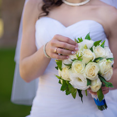 Obraz na płótnie Canvas bride holds fresh white bouquet closeup outdoor