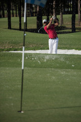 golfer hitting a sand bunker shot
