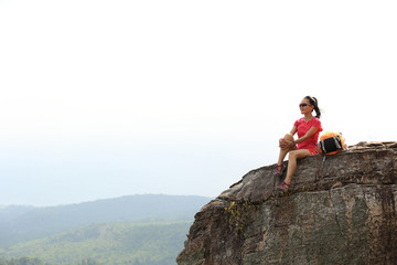 young woman hiker enjoy the view at mountain peak cliff