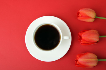 bouquet of red tulips on red wooden background with Cup of strong coffee