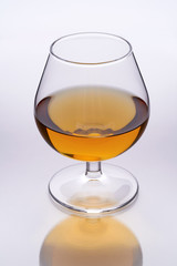 A glass of whisky on a reflective bar top surface with no edge highlights.