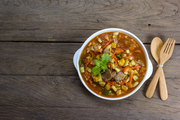 Sweet and sour sauce fried with pork on wood background