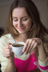 Young happy woman holding cup hot coffee tea sits  cafe, lifestyle, breakfast or dinner  spend time relaxing, healthy, fashion