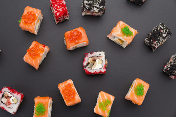 Japanese cuisine. Set of sushi mix roll with differen fresh ingredients over black background ( table ).