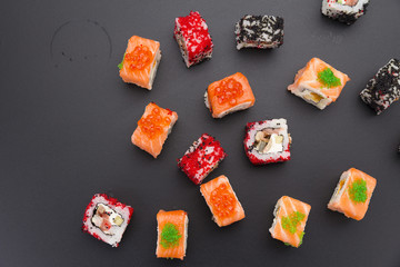 Japanese cuisine. Set of sushi mix roll with differen fresh ingredients over black background ( table ).