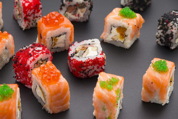 Japanese cuisine. Set of sushi mix roll with differen fresh ingredients over black background ( table ).