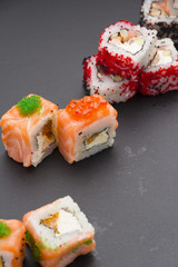 Japanese cuisine. Set of sushi mix roll with differen fresh ingredients over black background ( table ).
