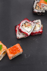 Japanese cuisine. Set of sushi mix roll with differen fresh ingredients over black background ( table ).