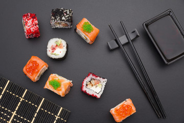 Japanese cuisine. Set of sushi mix roll with differen fresh ingredients over black background ( table ).