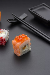 Japanese cuisine. Set of sushi mix roll with differen fresh ingredients over black background ( table ).