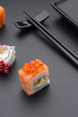 Japanese cuisine. Set of sushi mix roll with differen fresh ingredients over black background ( table ).