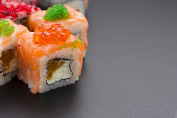 Japanese cuisine. Set of sushi mix roll with differen fresh ingredients over black background ( table ).