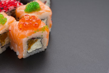 Japanese cuisine. Set of sushi mix roll with differen fresh ingredients over black background ( table ).