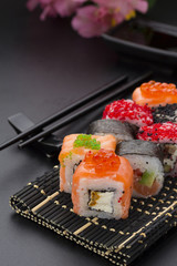 Japanese cuisine. Set of sushi mix roll with differen fresh ingredients over black background ( table ).