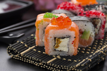 Japanese cuisine. Set of sushi mix roll with differen fresh ingredients over black background ( table ).