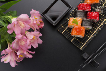 Japanese cuisine. Set of sushi mix roll with differen fresh ingredients over black background ( table ).
