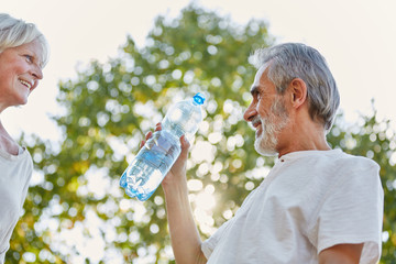 Senioren trinken eine Flasche Wasser