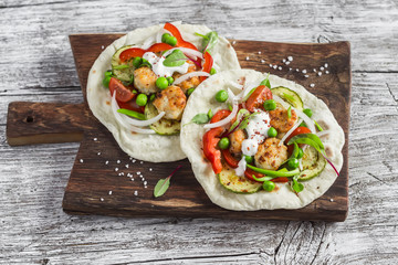 Chicken meatballs and fresh vegetables tortilla on a wooden rustic board. Healthy tasty food