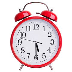 Red alarm clock shows half past five