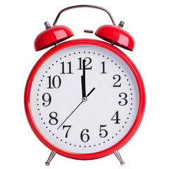 Red alarm clock shows five minutes to two