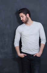 a young man with a beard on a chalkboard background with the emo