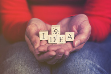 Hands holding Idea message formed with wooden blocks