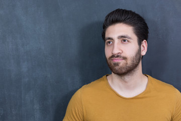 Attractive young man against blackboard.