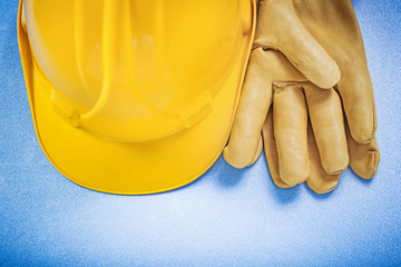 Composition of hard hat leather safety gloves on blue background